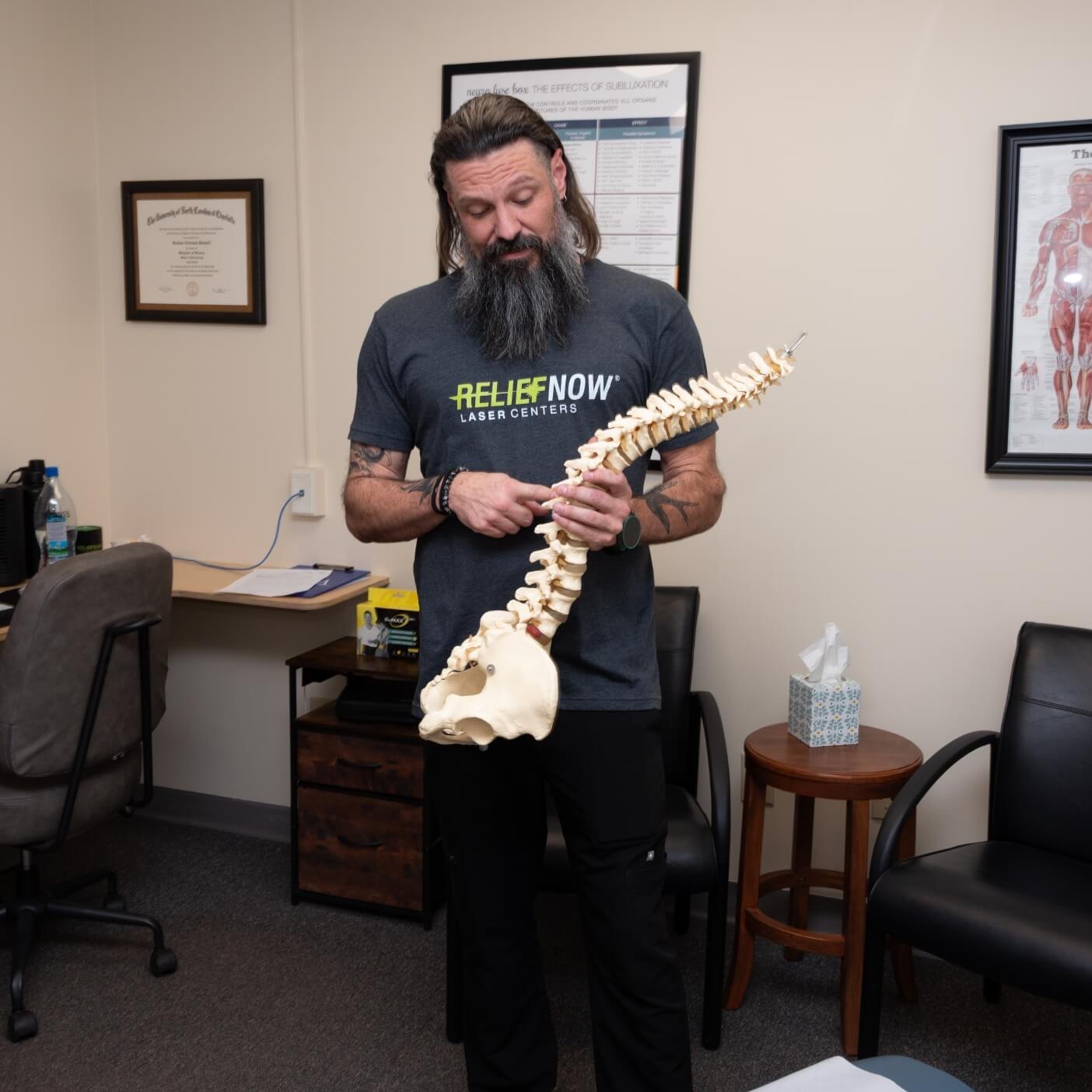 Dr. Coleman Pannell holding a model of the spine